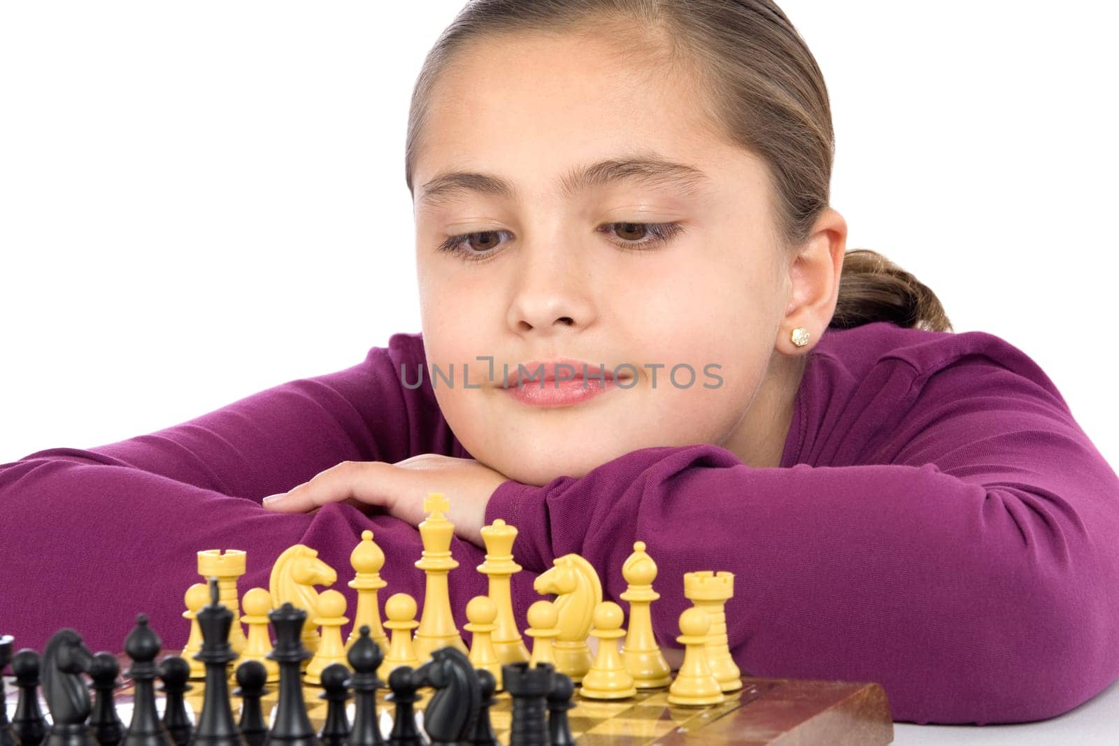 Attractive little girl playing chess