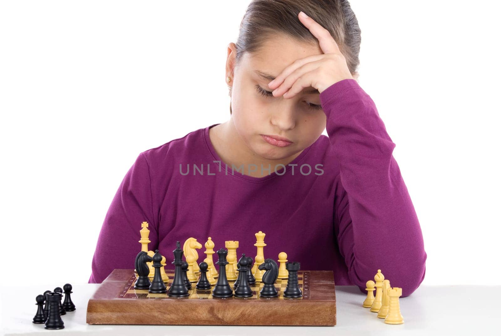 Worried little girl playing chess