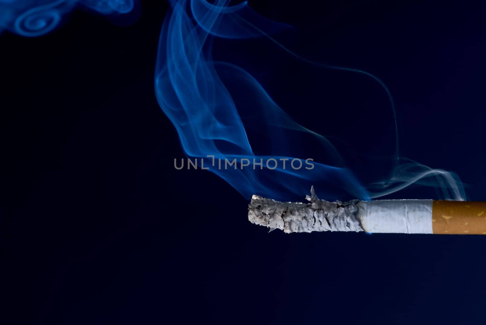 burning cigarette with smoke, isolated over black