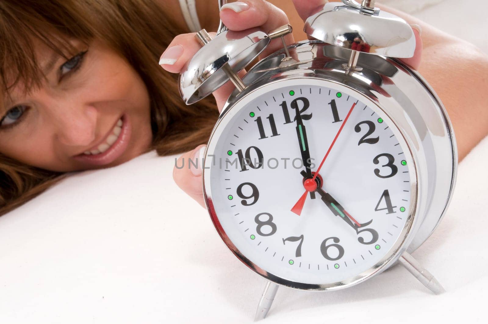 Woman in bed with alarm clock