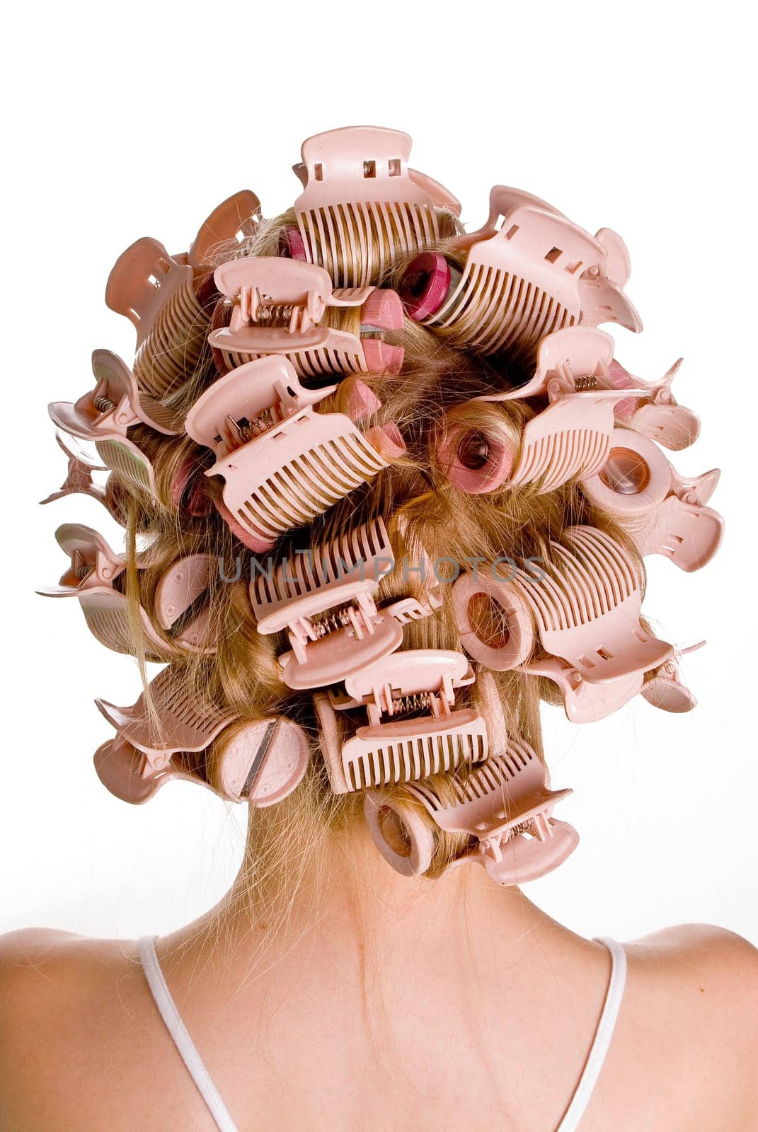 Young beautiful girl is having hair curlers on her head