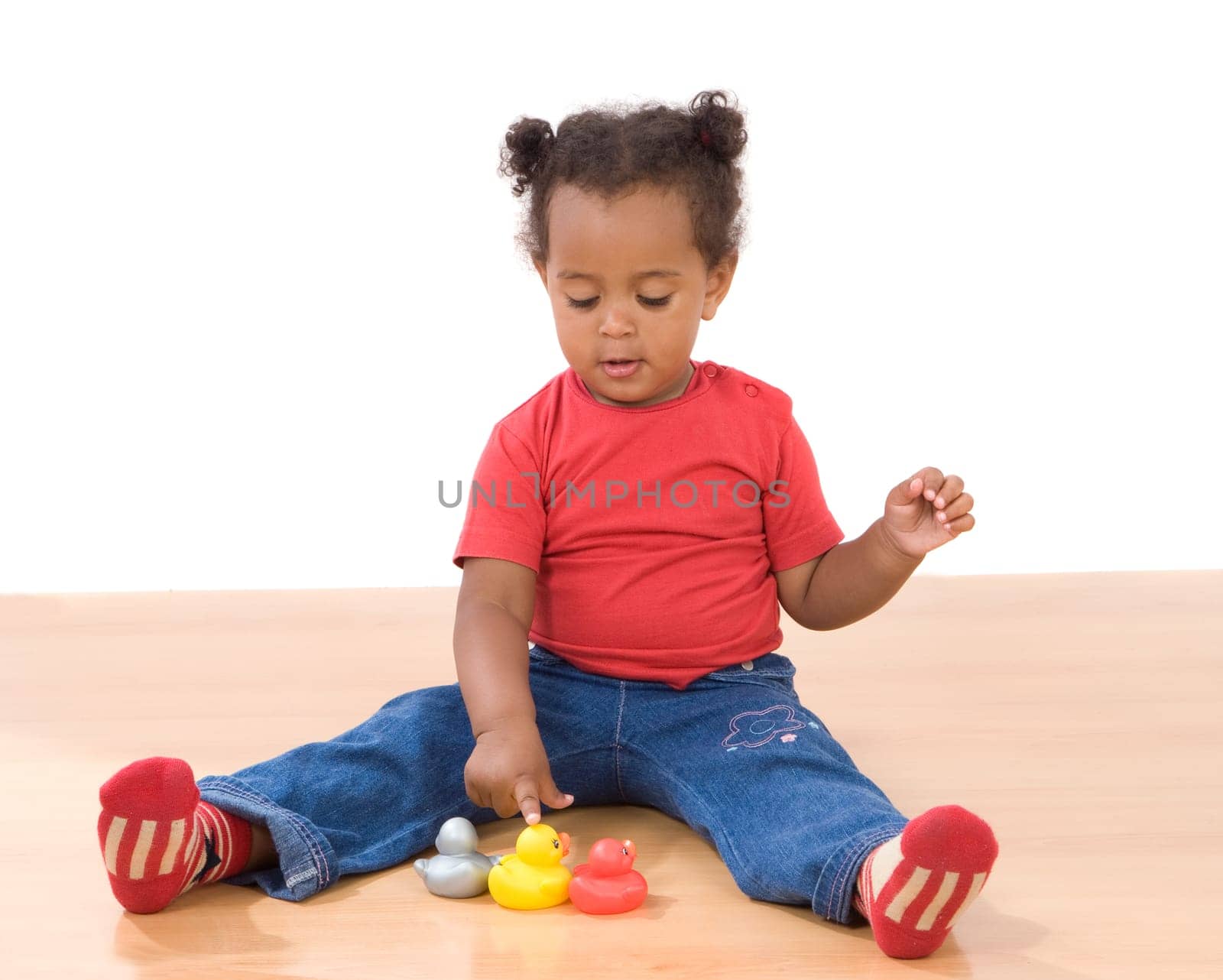 Girl playing with three ducks of plastic