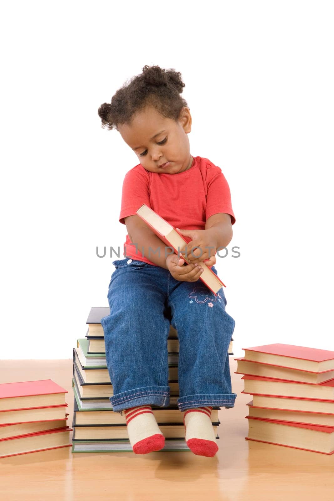 Baby reading sitting on a pile of books