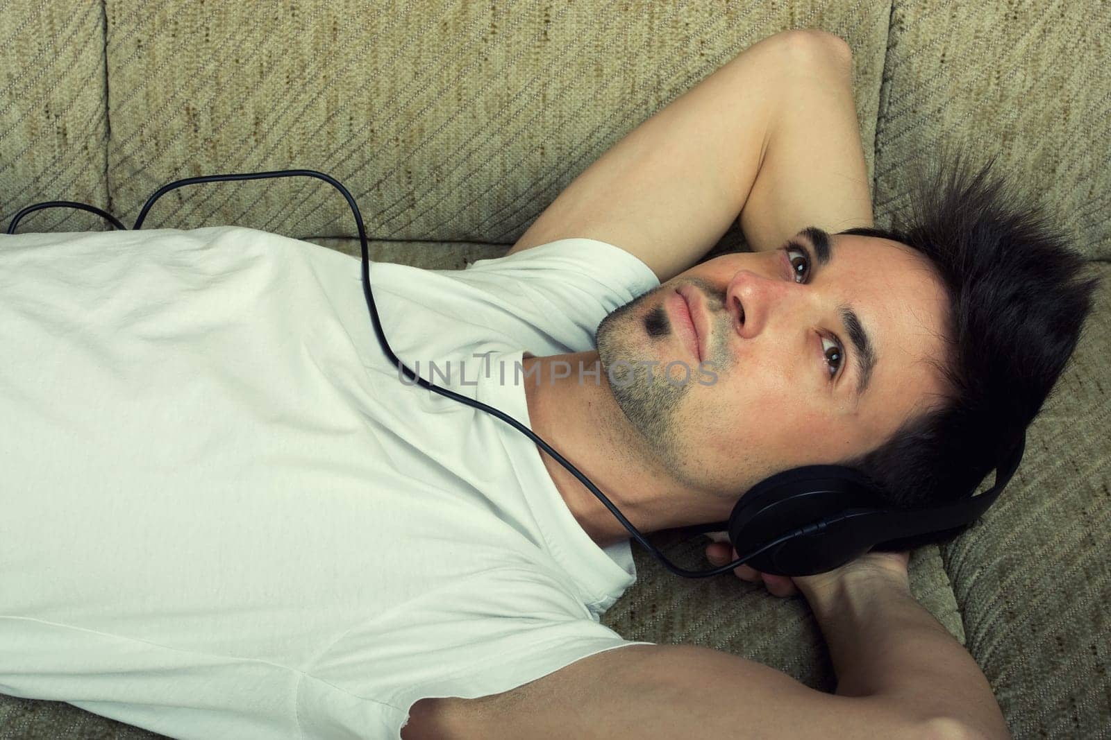 Laying young man listening music