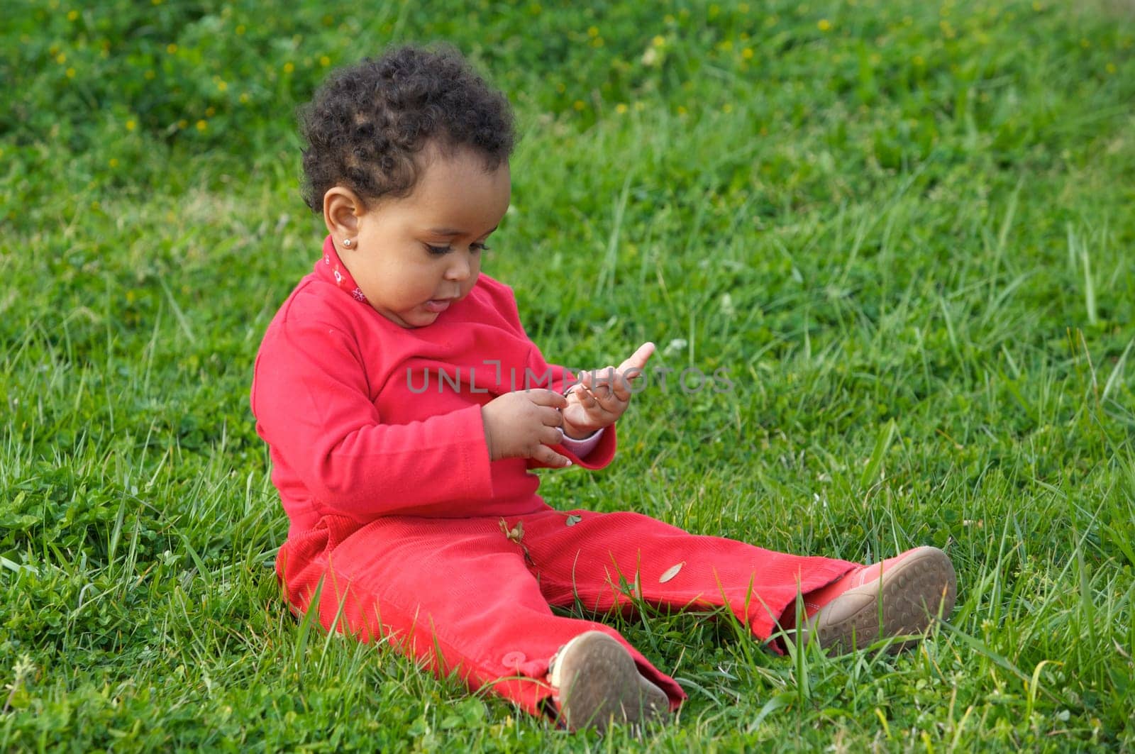 Adorable baby sitting on the grass