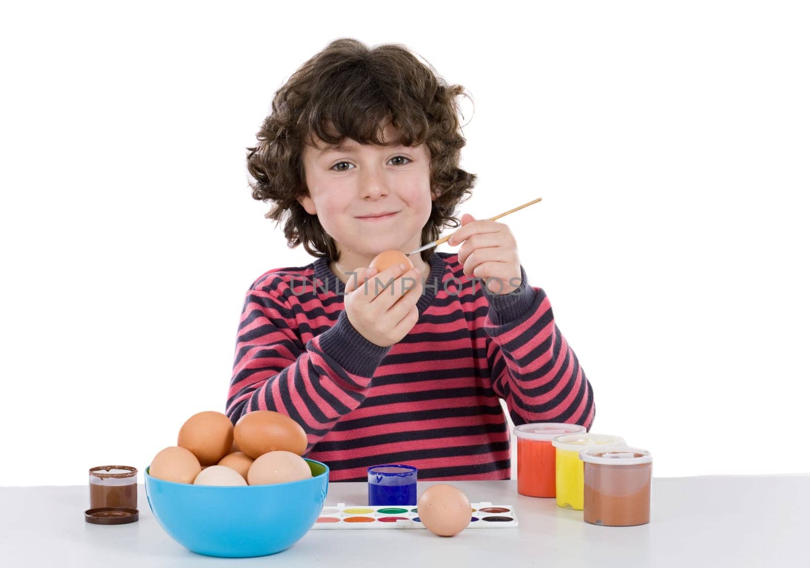Child adorable adorning Easter eggs