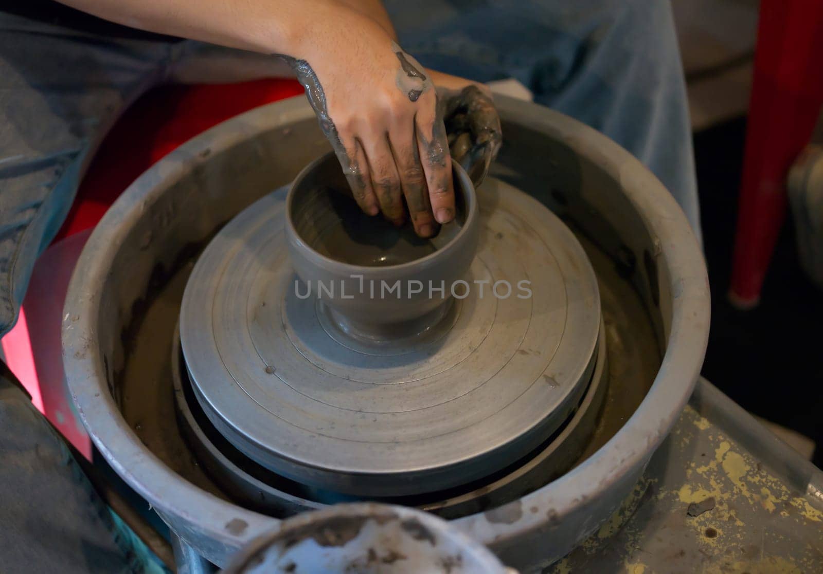 Hands making ceramic cup on potter's wheel . Concept workshop  by Hepjam