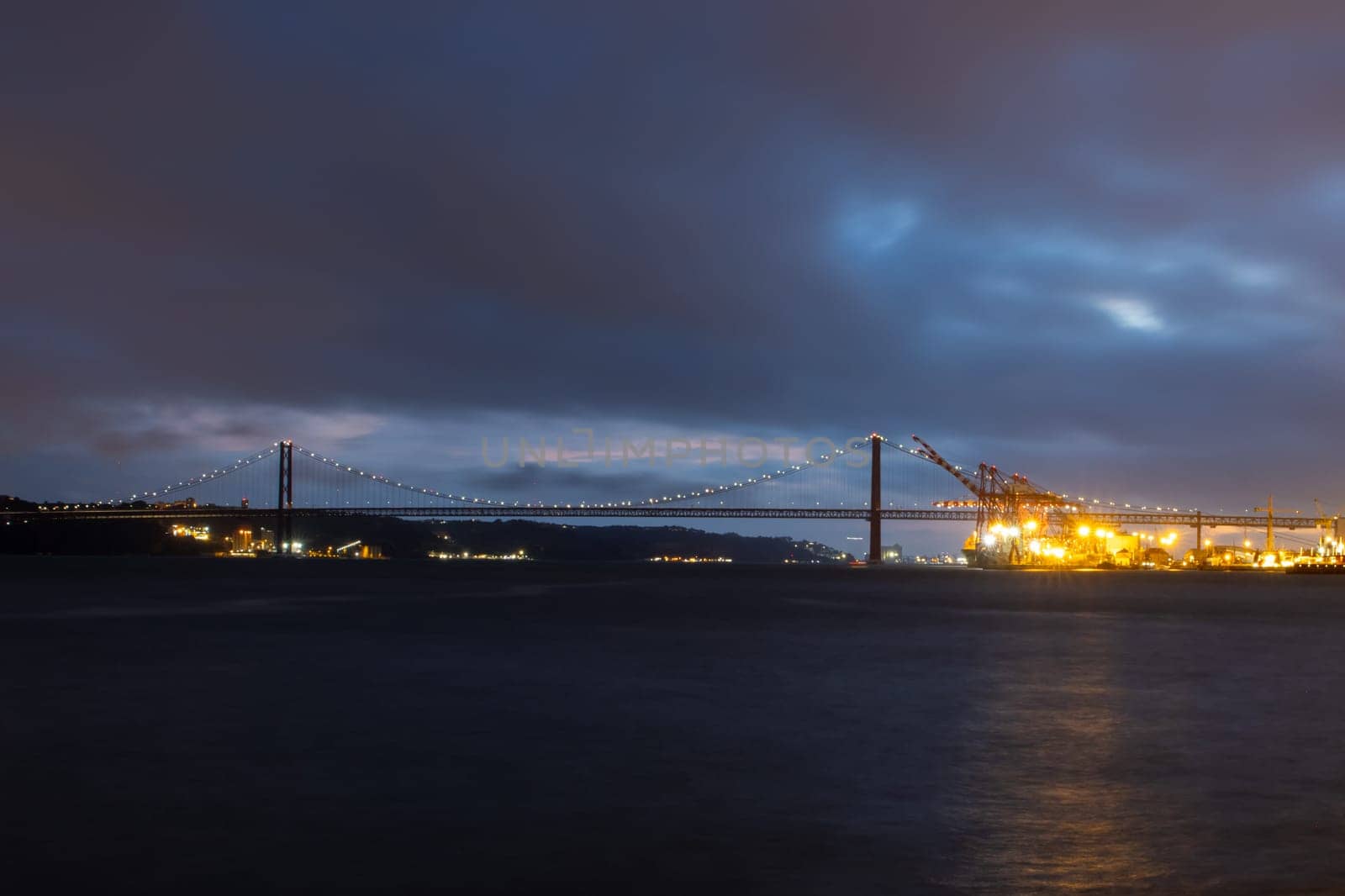Tagus river and 25th of april bridge - night landscape. Mid shot