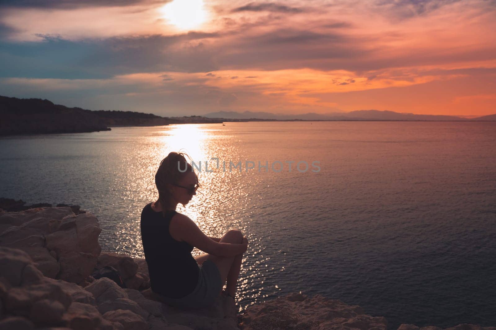 Silhouette of a girl standing on the beach enjoy freedom at the beach at sunset. Vacation concept. by PaulCarr