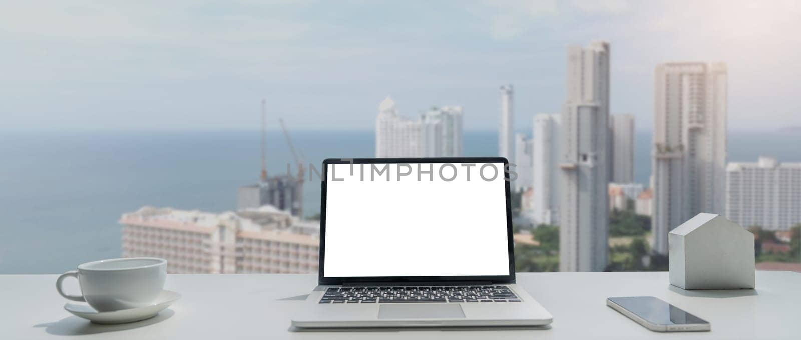 Image of working space by the window equipment in office interior, open laptop computer with mock up screen by nateemee