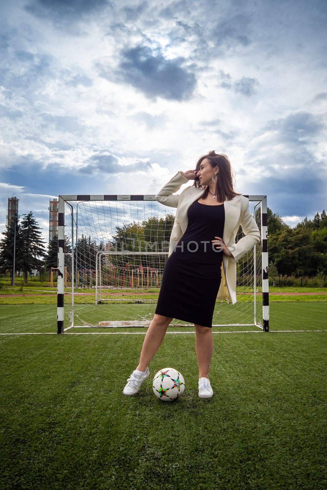 portrait of a beautiful woman football player in a strict office suit. concept sports office manager leisure