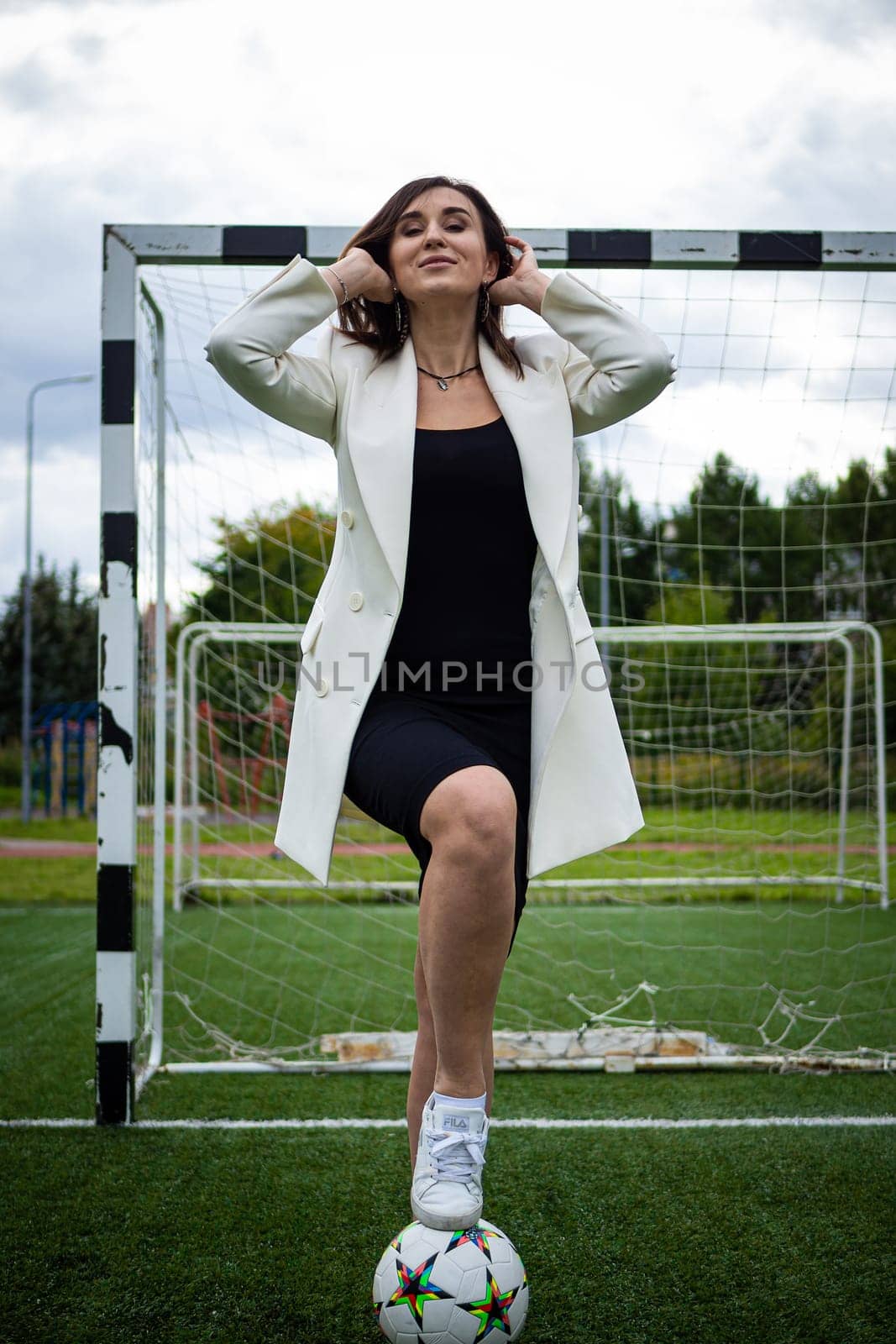 portrait of a beautiful woman football player in a strict office suit. concept sports office manager leisure