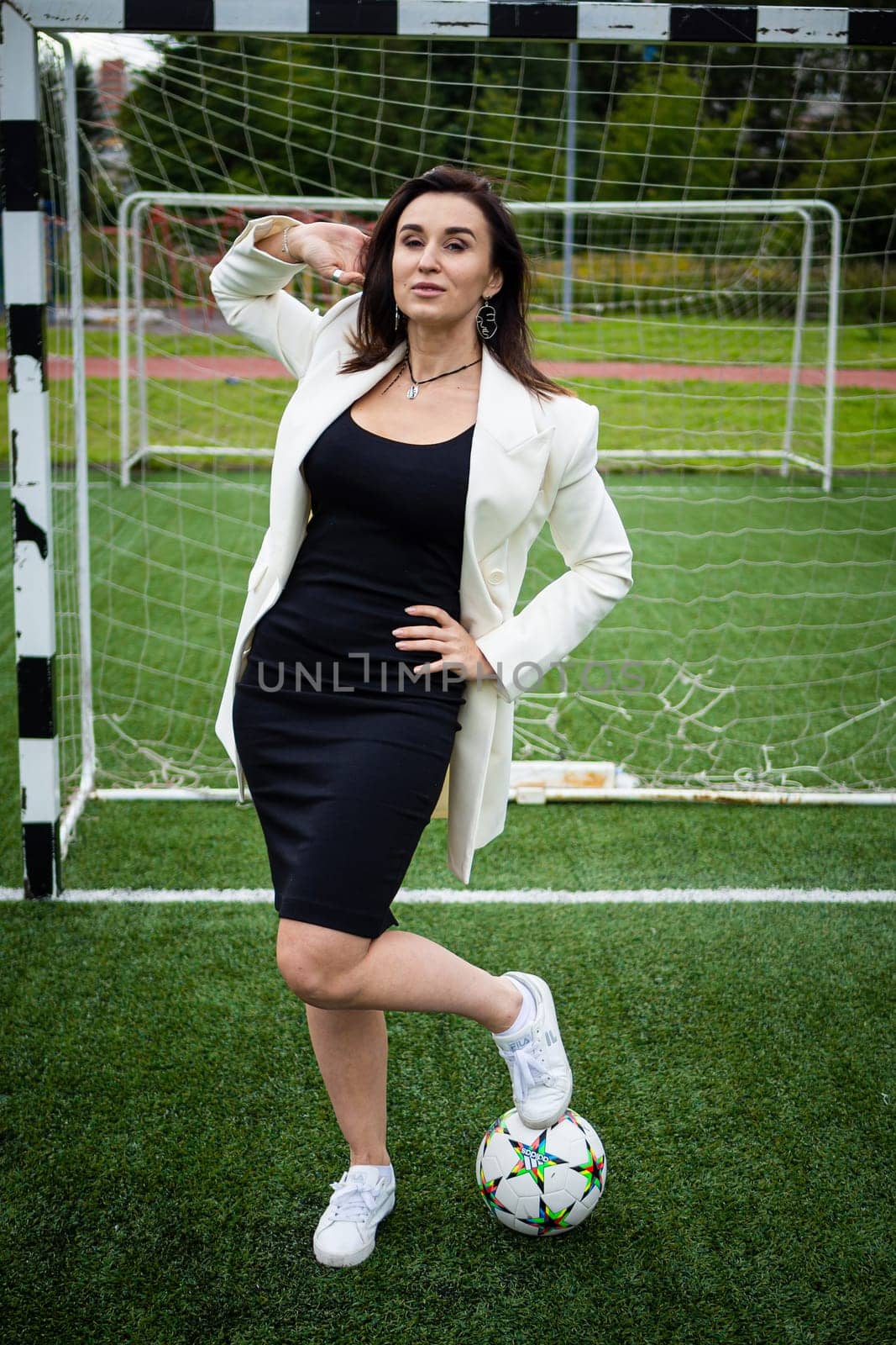 portrait of a beautiful woman football player in a strict office suit. concept sports office manager leisure