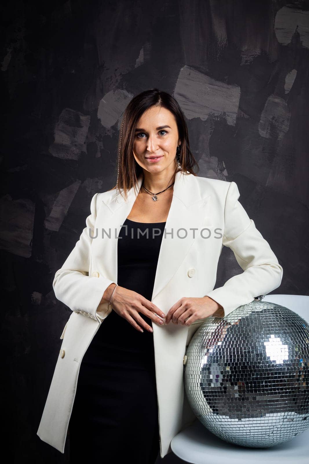 Portrait of a woman holding a silver disco ball. Taken in a photo studio. by Evgenii_Leontev