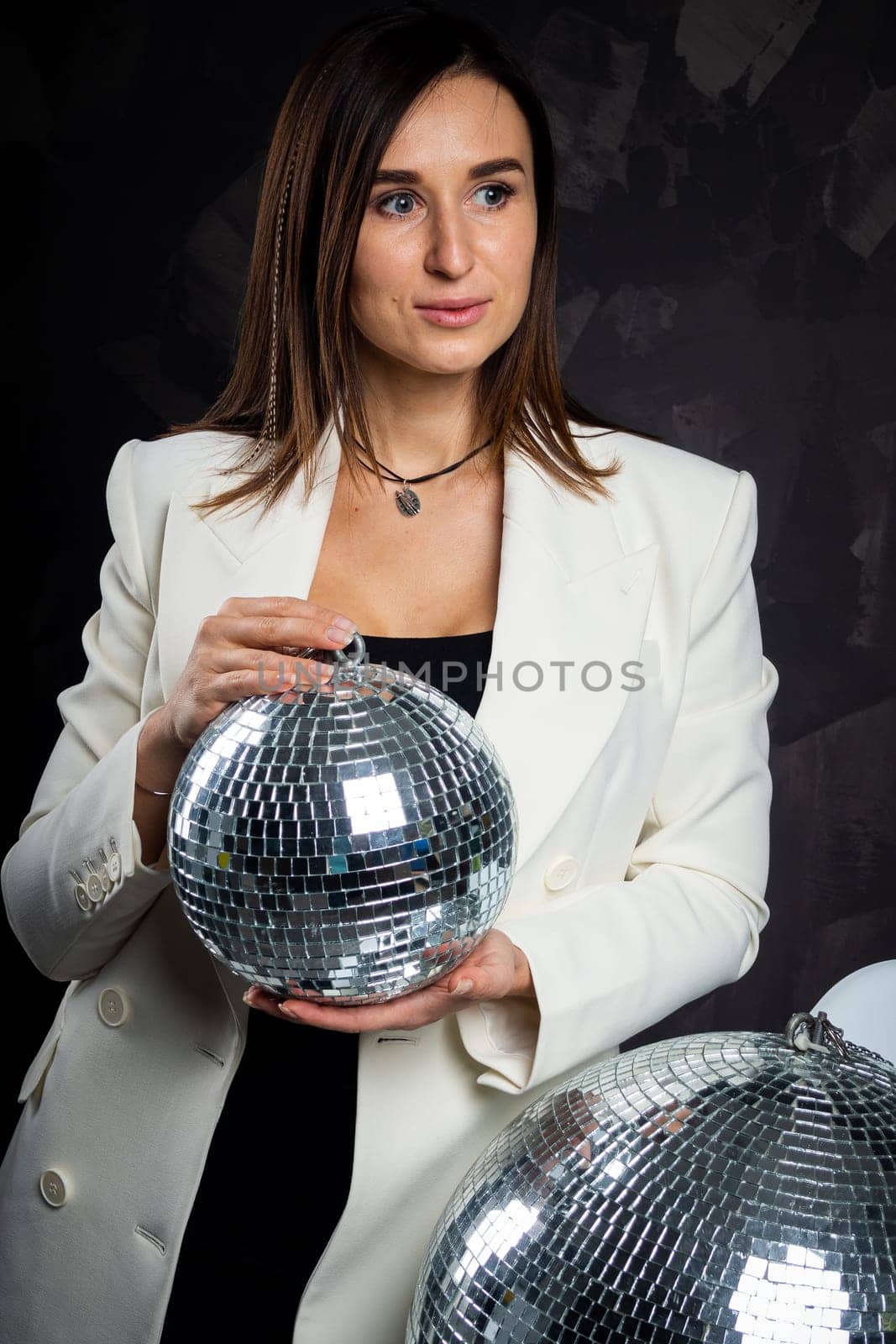 Portrait of a woman holding a silver disco ball. Taken in a photo studio. by Evgenii_Leontev