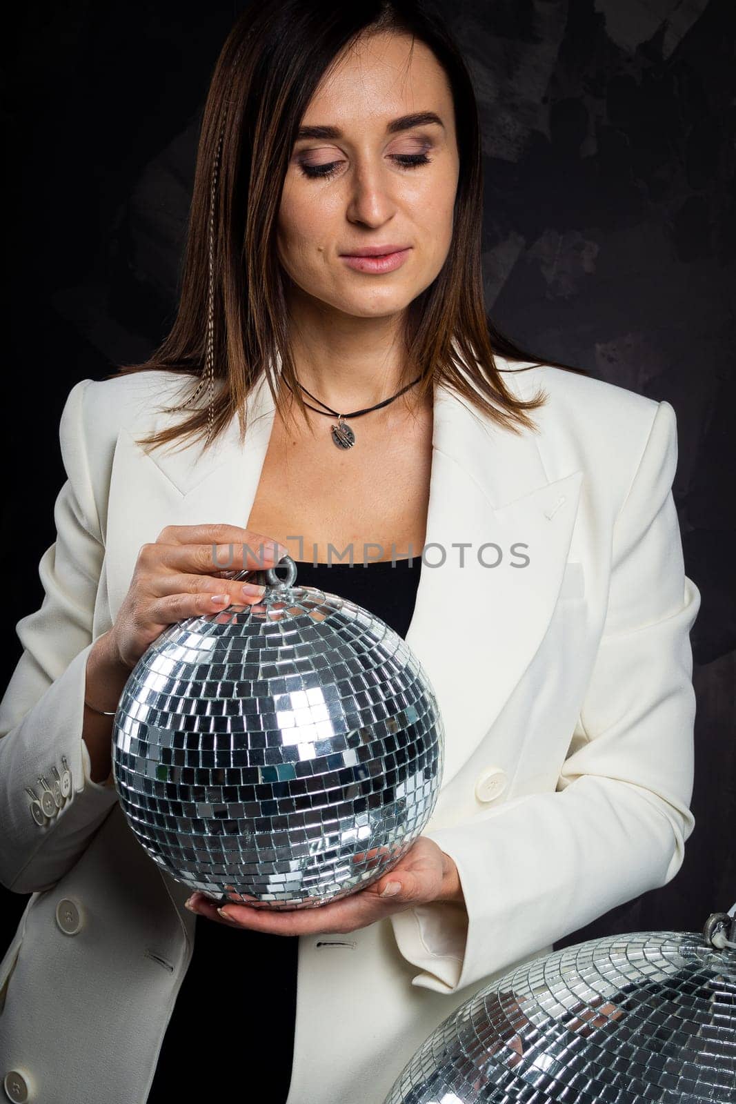 Portrait of a woman holding a silver disco ball. Taken in a photo studio. by Evgenii_Leontev