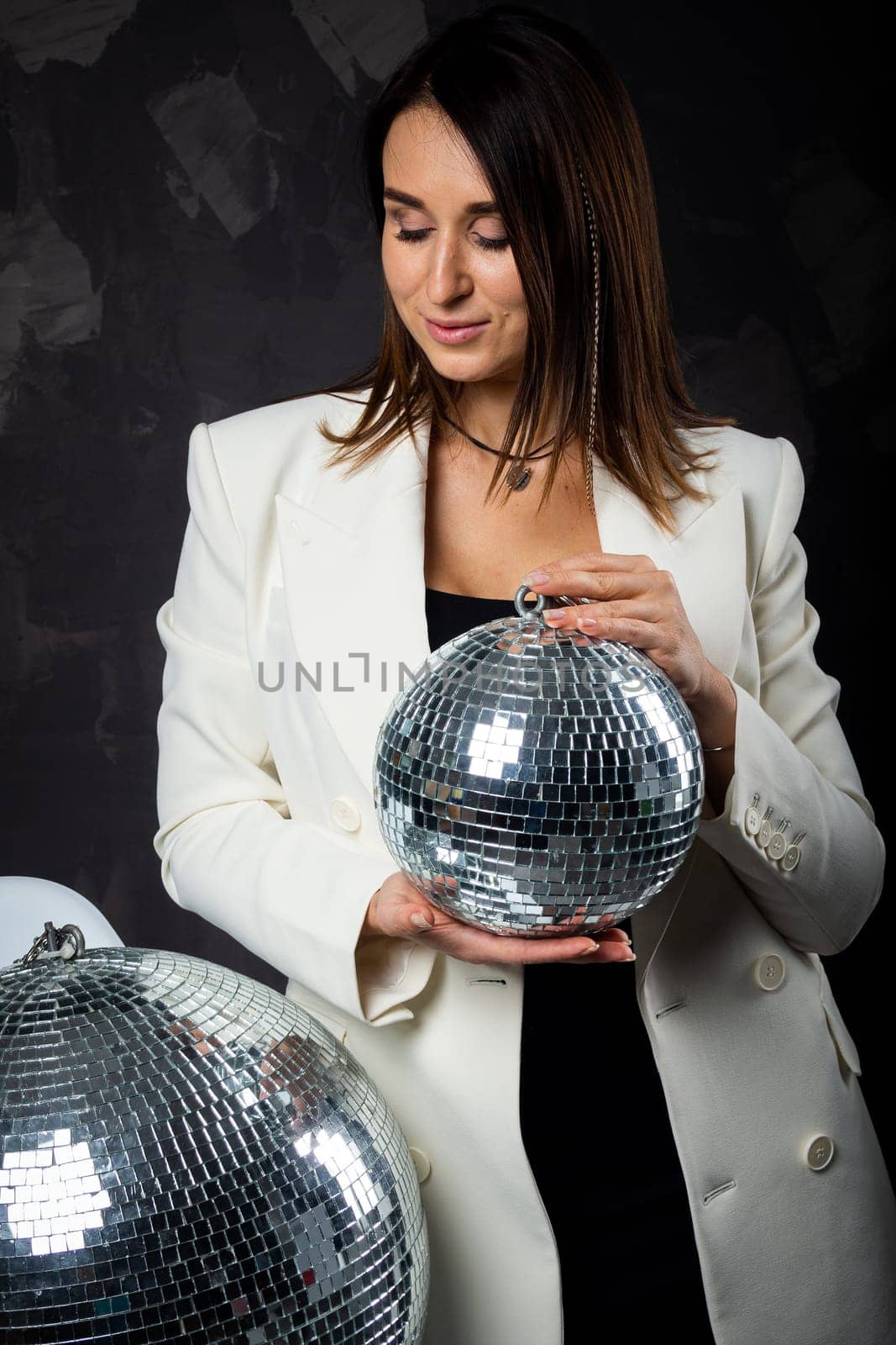 Portrait of a woman holding a silver disco ball. Taken in a photo studio. by Evgenii_Leontev