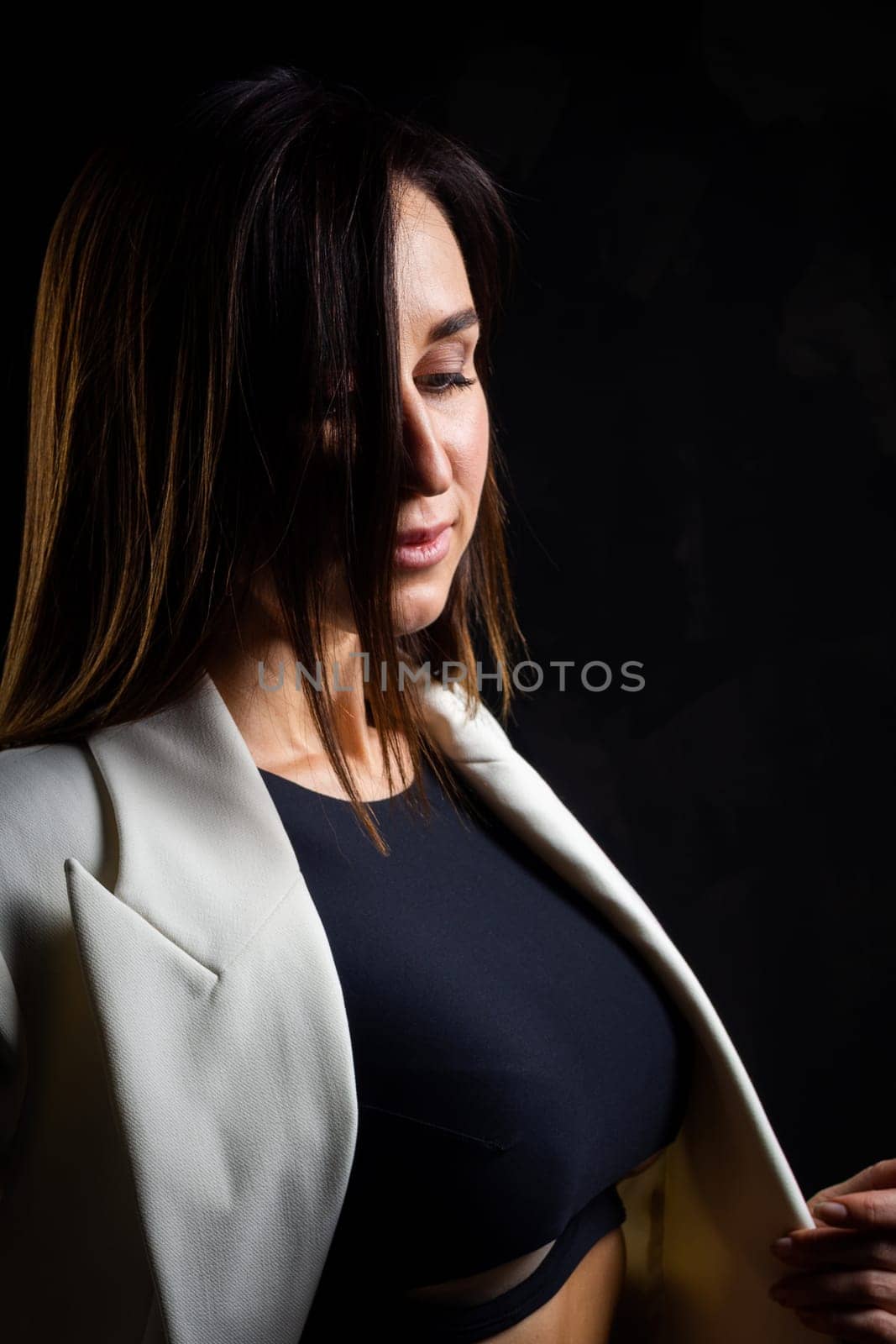 A business woman showing off her body in her underwear. Shot in the studio on a dark background.