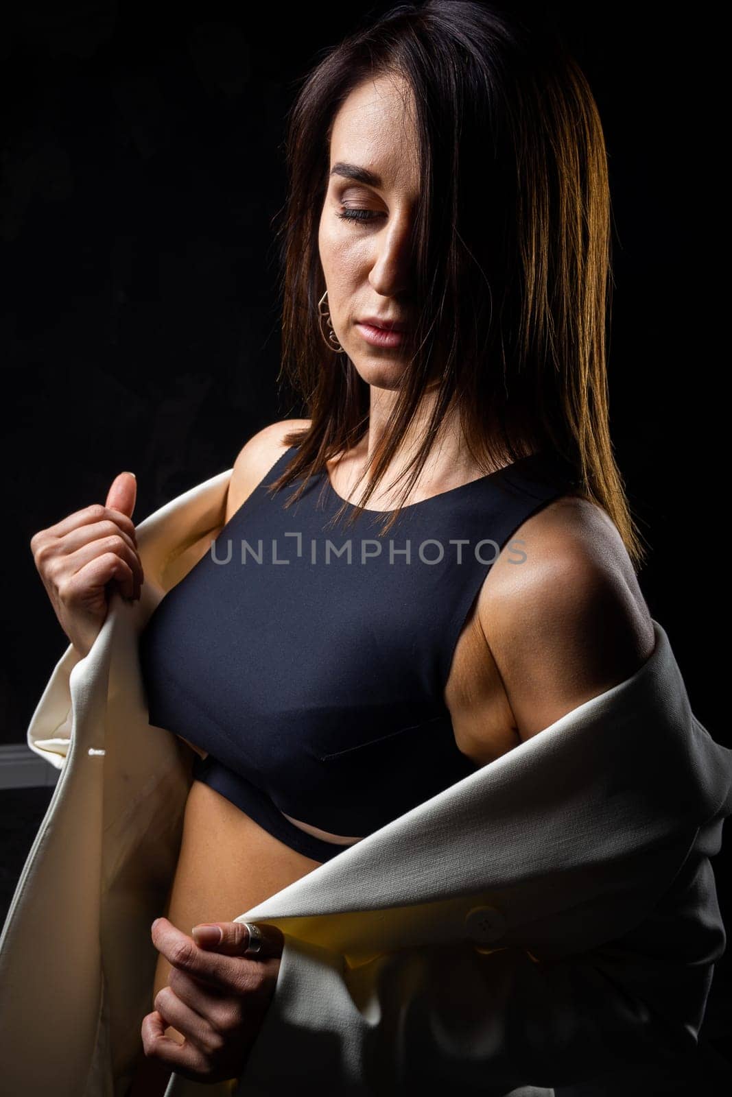 A business woman showing off her body in her underwear. Shot in the studio on a dark background.