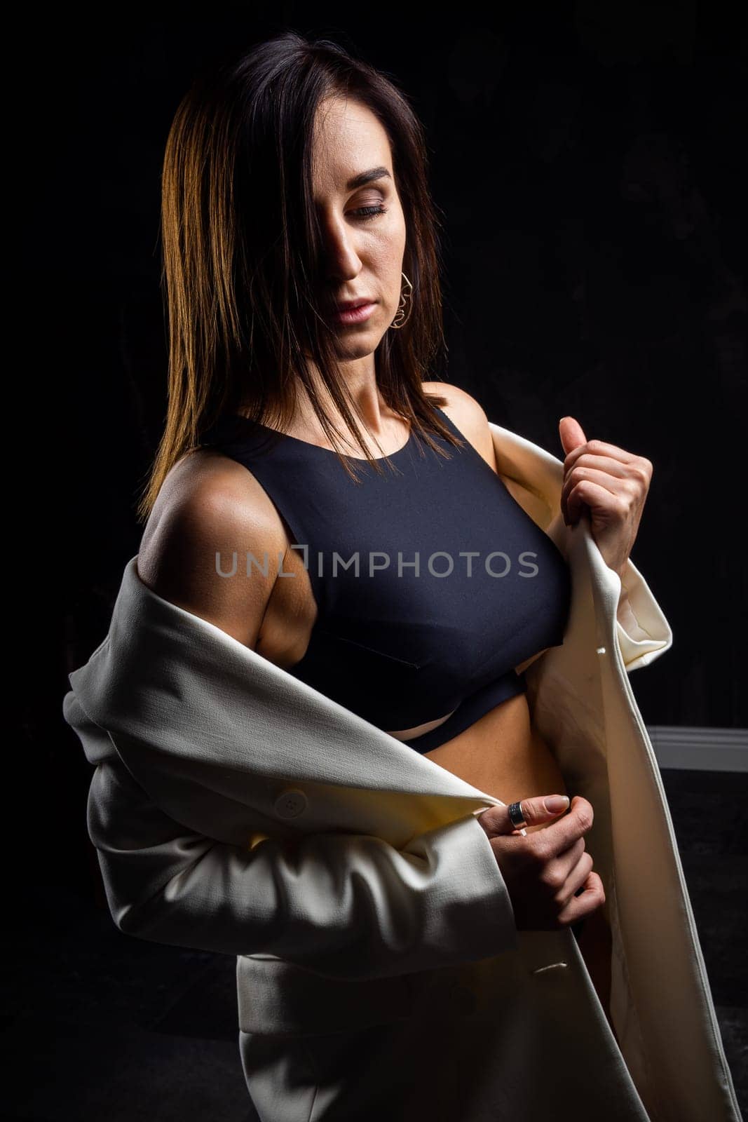 A business woman showing off her body in her underwear. Shot in the studio on a dark background.