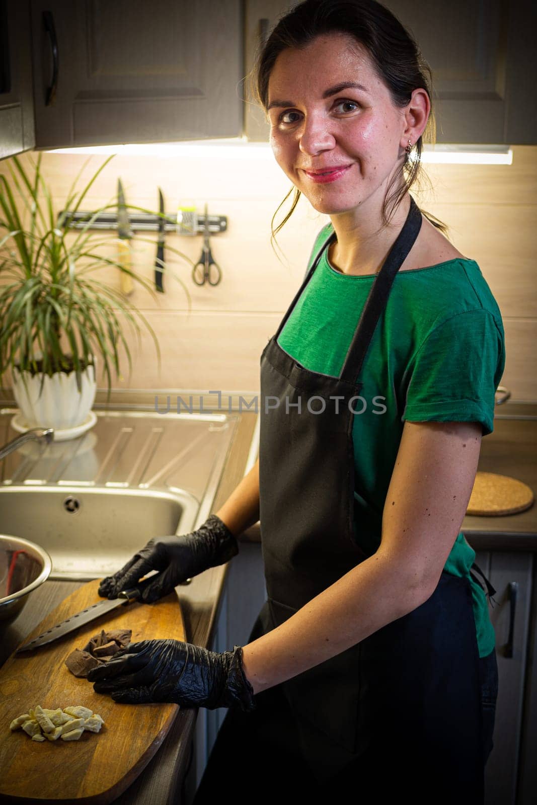 Woman cooking tasty melted chocolate on table in kitchen. Delicious dessert made of homemade chocolate.