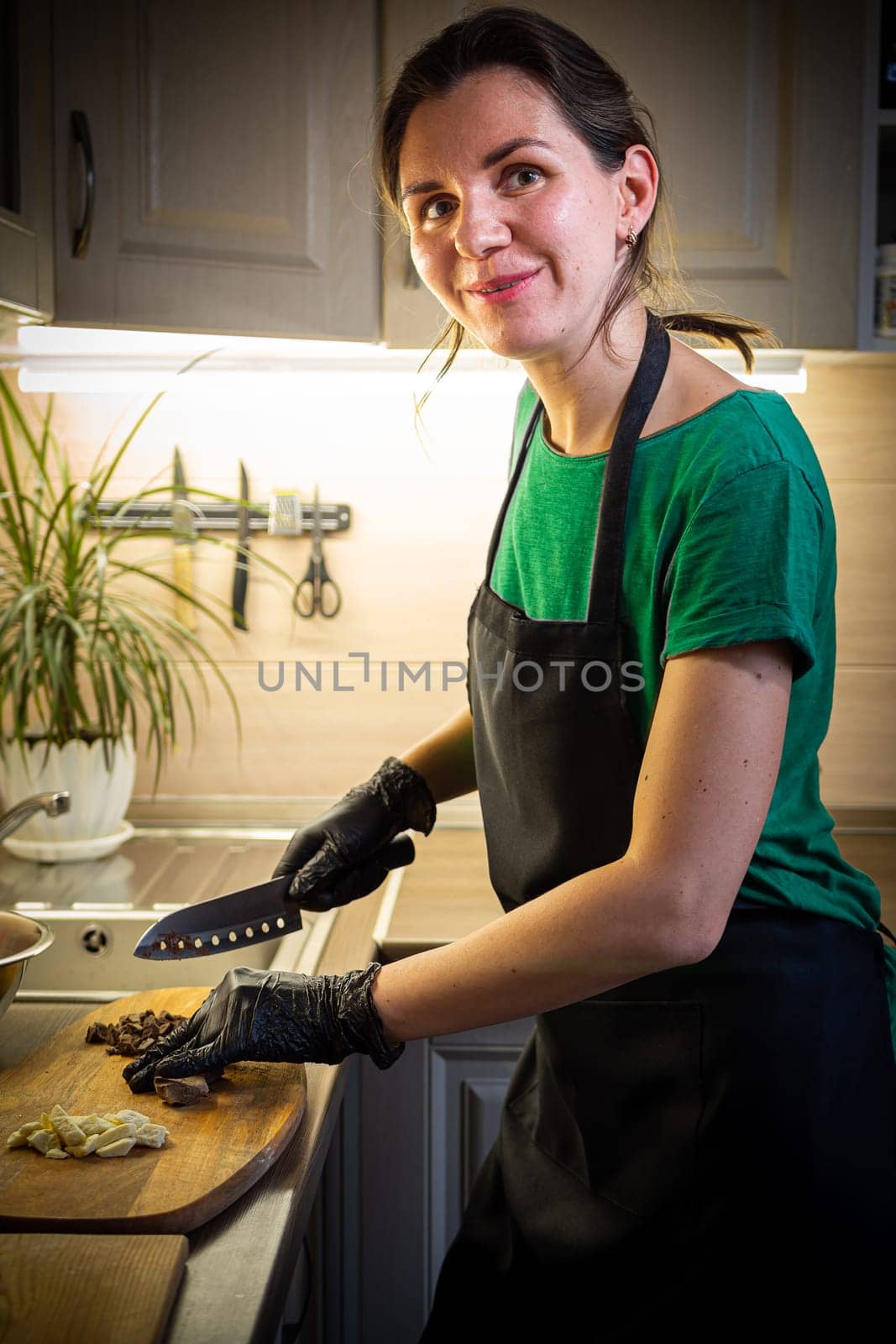 Woman cooking tasty melted chocolate on table in kitchen. by Evgenii_Leontev