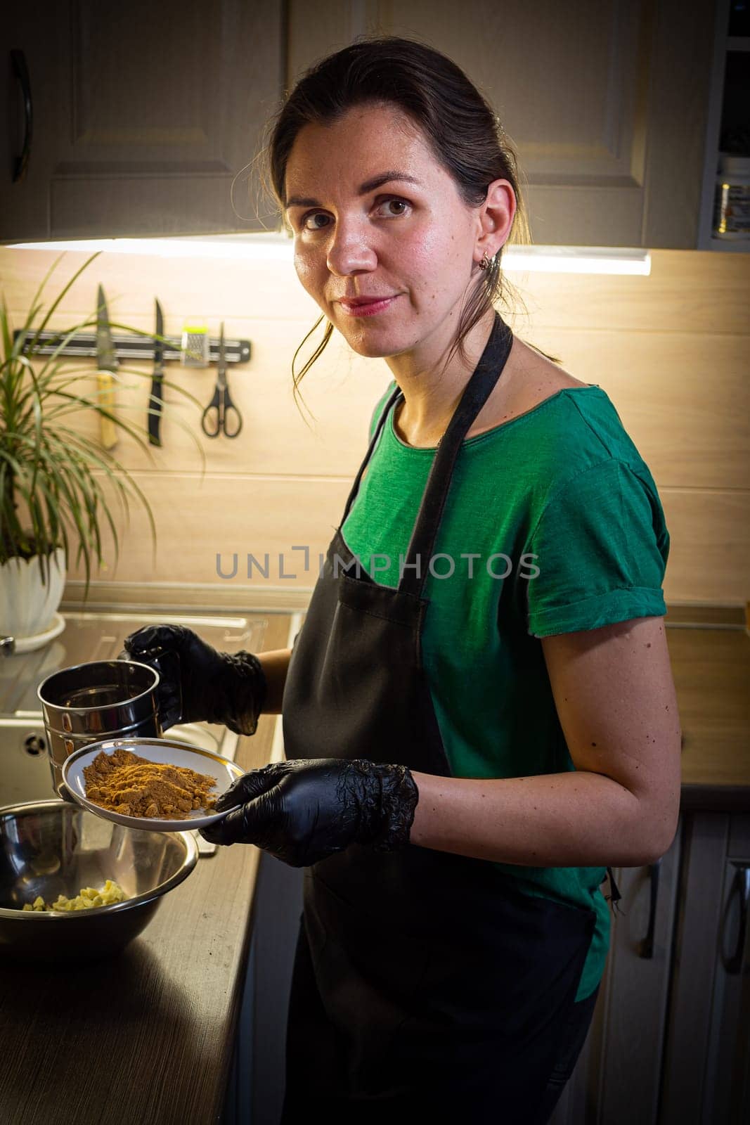 Woman cooking tasty melted chocolate on table in kitchen. Delicious dessert made of homemade chocolate.