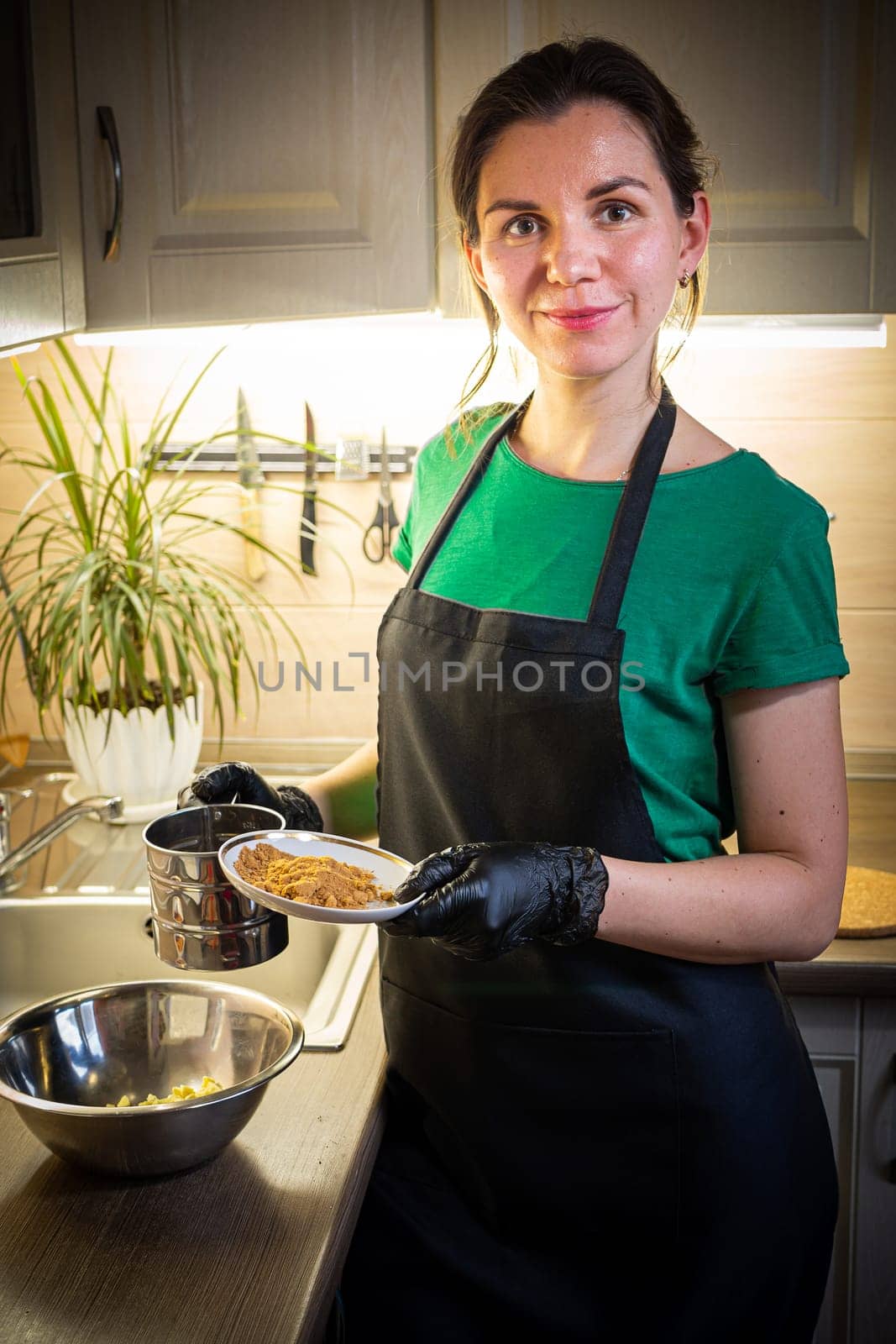 Woman cooking tasty melted chocolate on table in kitchen. Delicious dessert made of homemade chocolate.