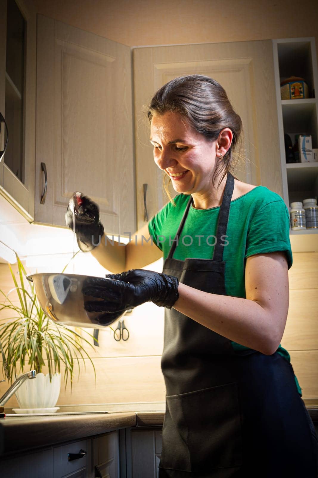 Woman cooking tasty melted chocolate on table in kitchen. Delicious dessert made of homemade chocolate.