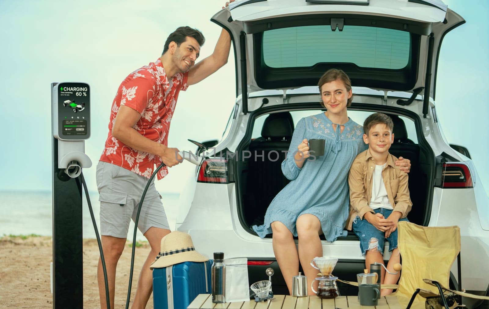 Family vacation trip traveling by the beach with electric car, happy family recharge EV car, enjoying outdoor camping coffee. Seascape travel and eco-friendly car for clean environment. Perpetual