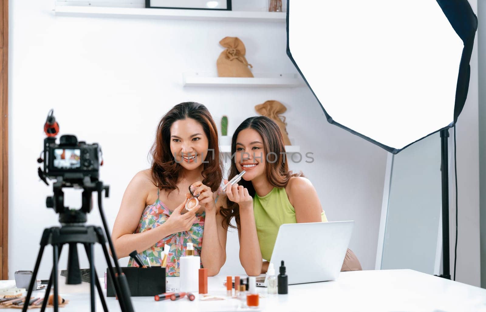 Woman influencer shoot live streaming vlog video review makeup uttermost social media or blog. Happy young girl with cosmetics studio lighting for marketing recording session broadcasting online.