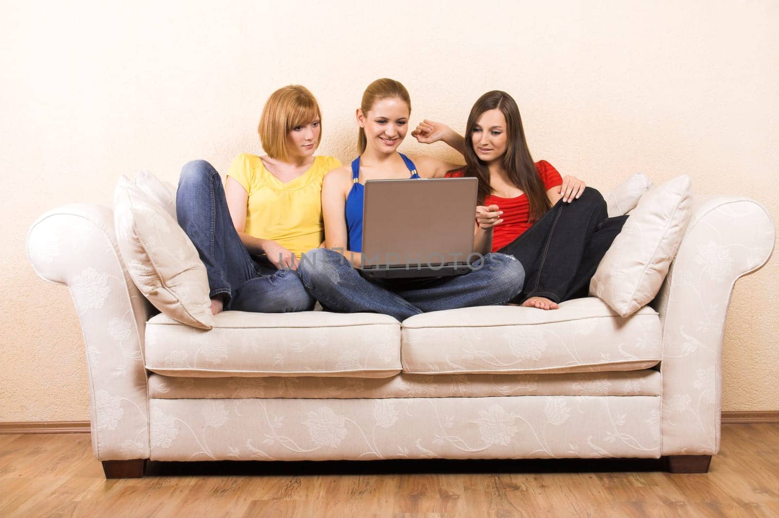 Three women on a sofa with laptop