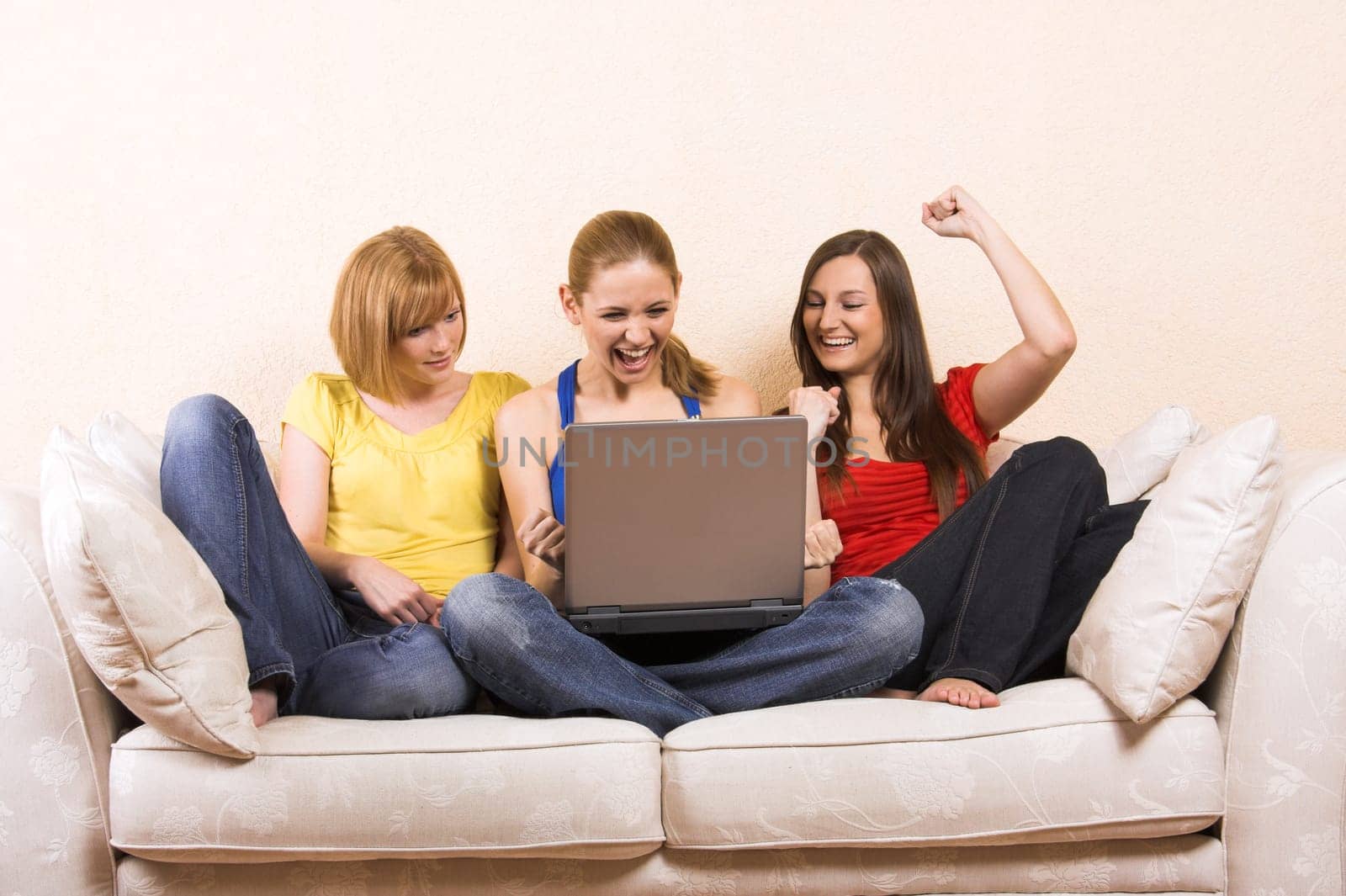 Three women on a sofa with laptop