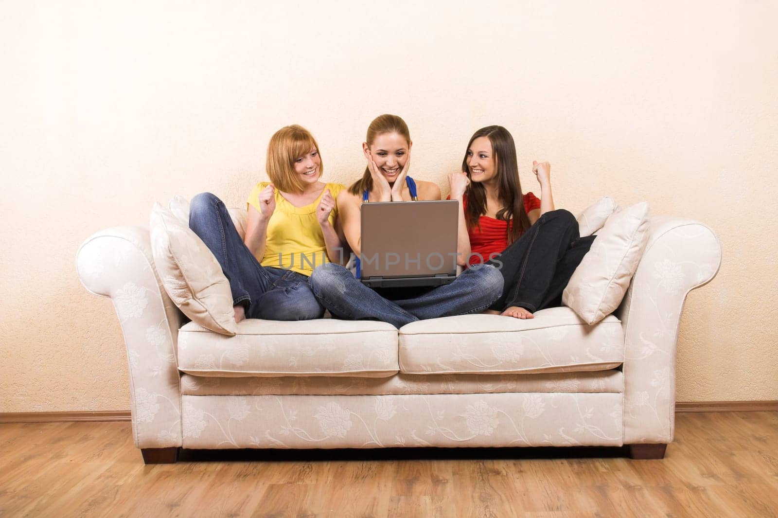 Three women on a sofa with laptop