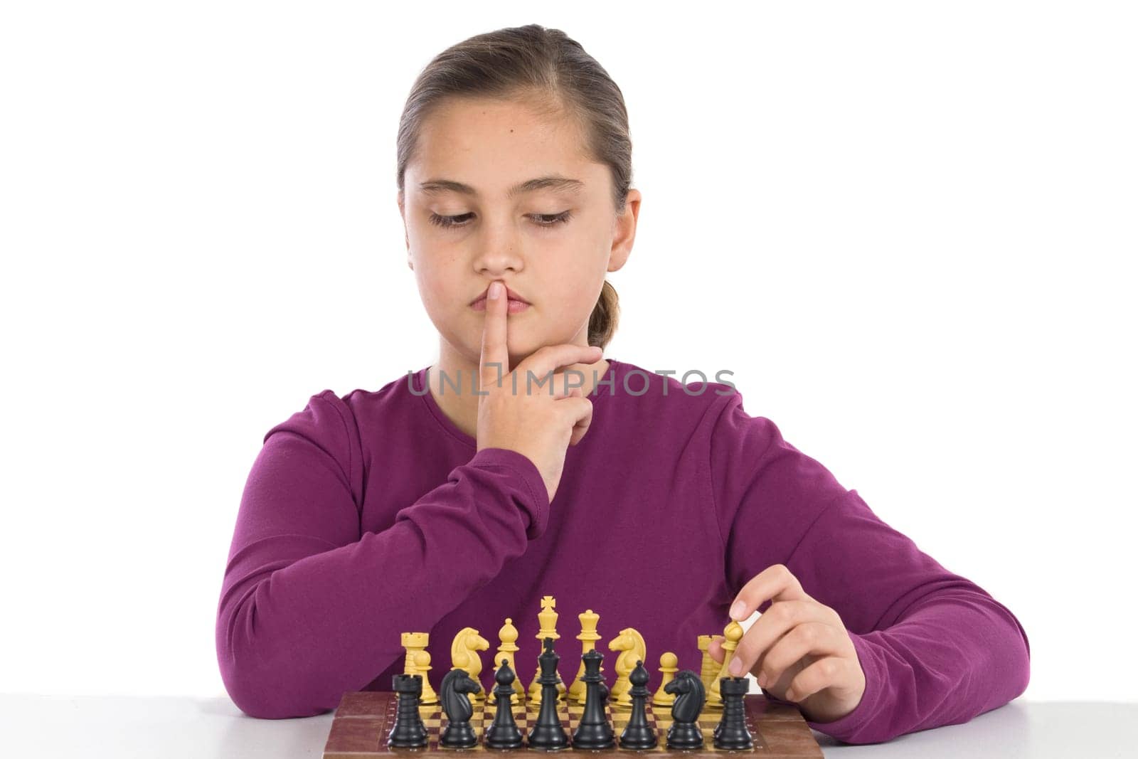Attractive little girl playing chess