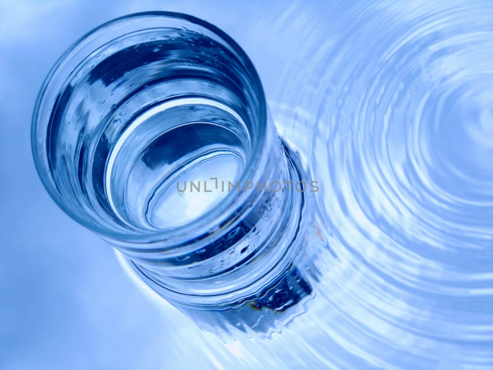 Glass of water in blue