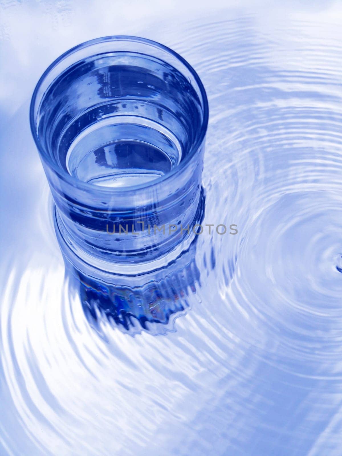 Glass of water in blue