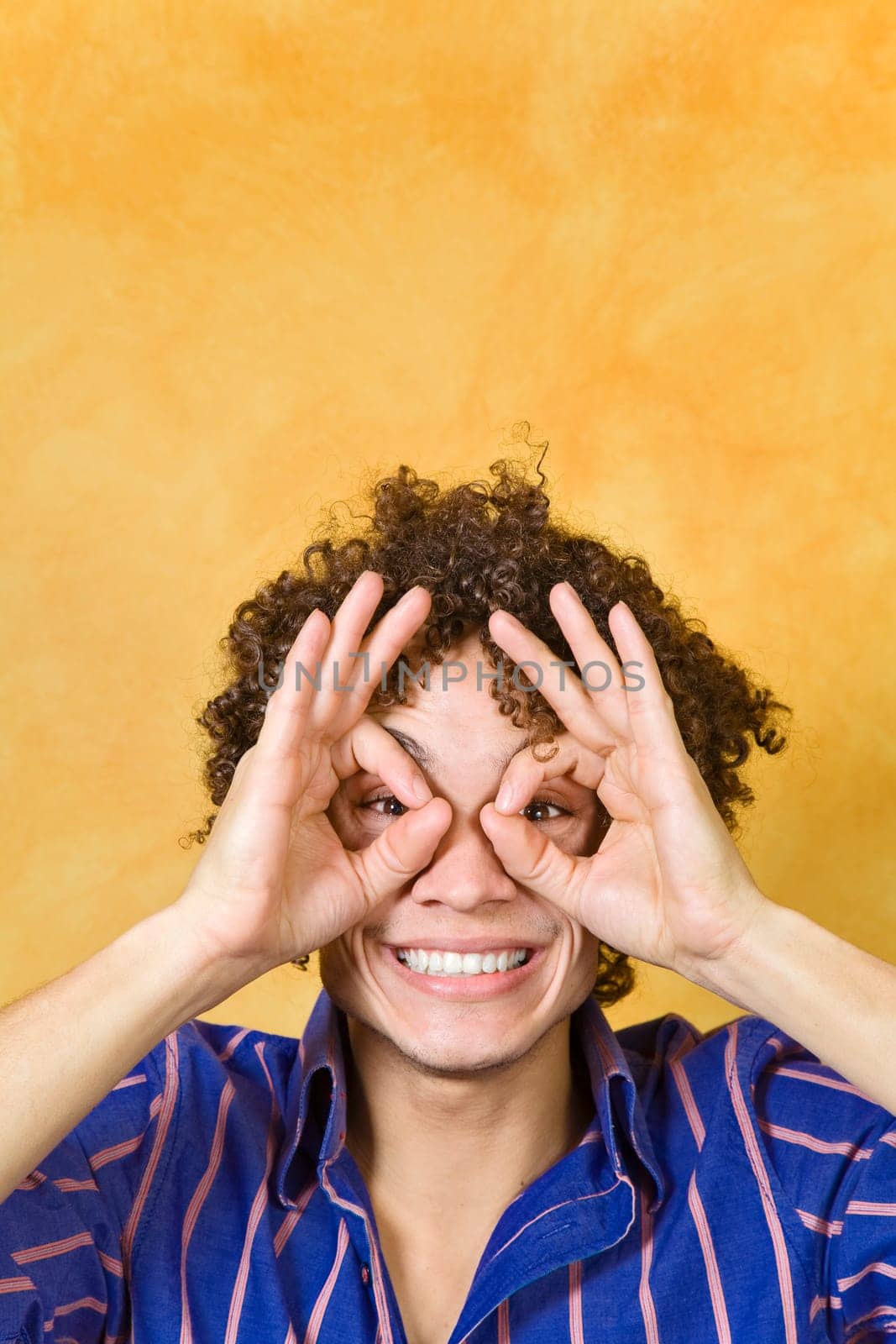 man smiling with hand over eyes