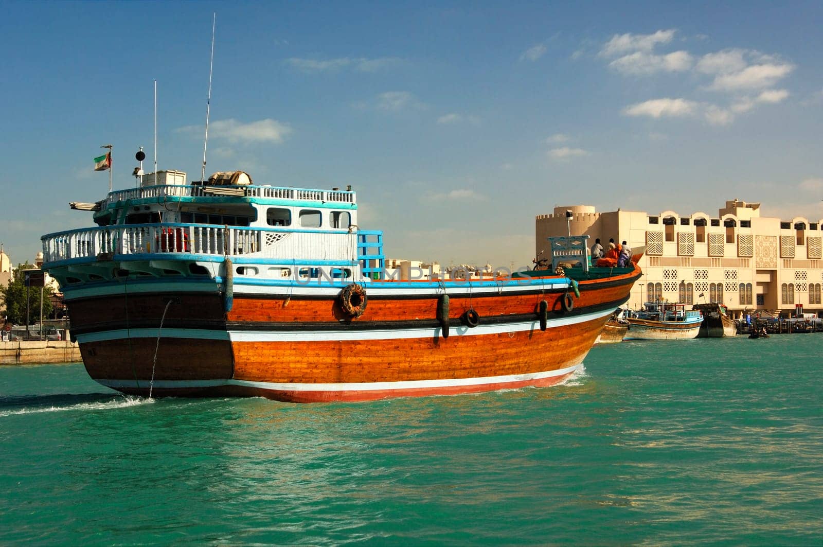 An empty dhow merchant ship sails upstream on the creek of Dubai,Verei