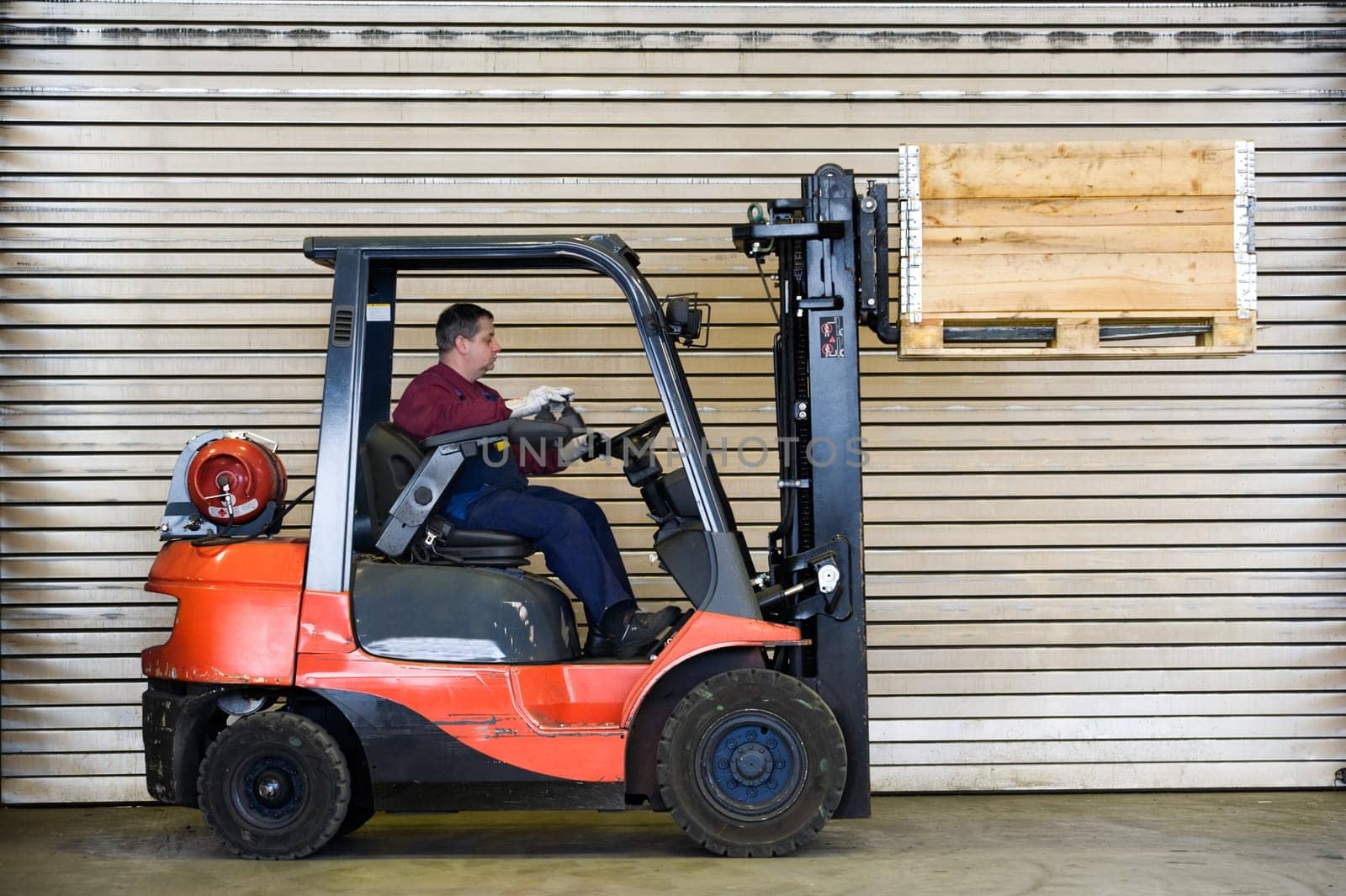 Man on forklift transports crate