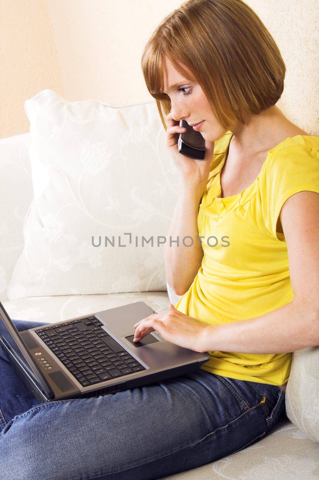 Woman using laptop and phone
