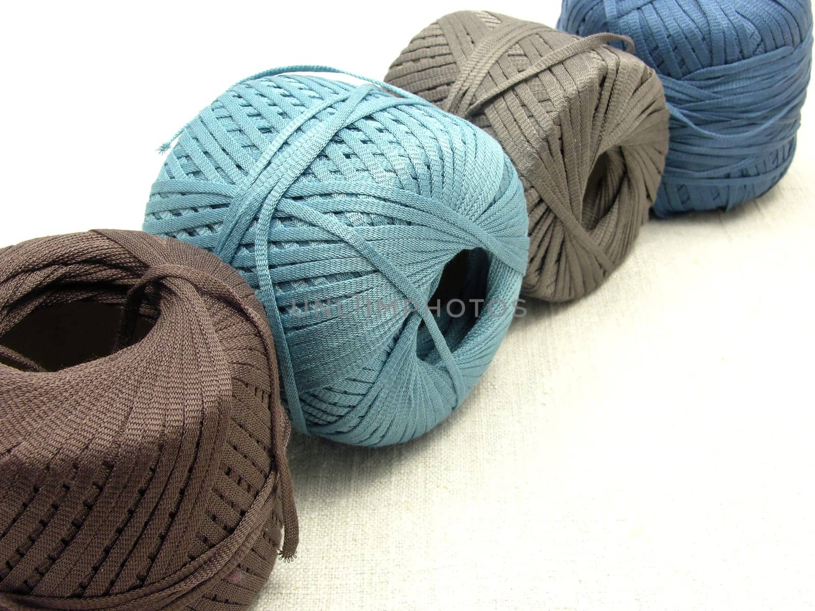 Four balls of yarn in a line on set