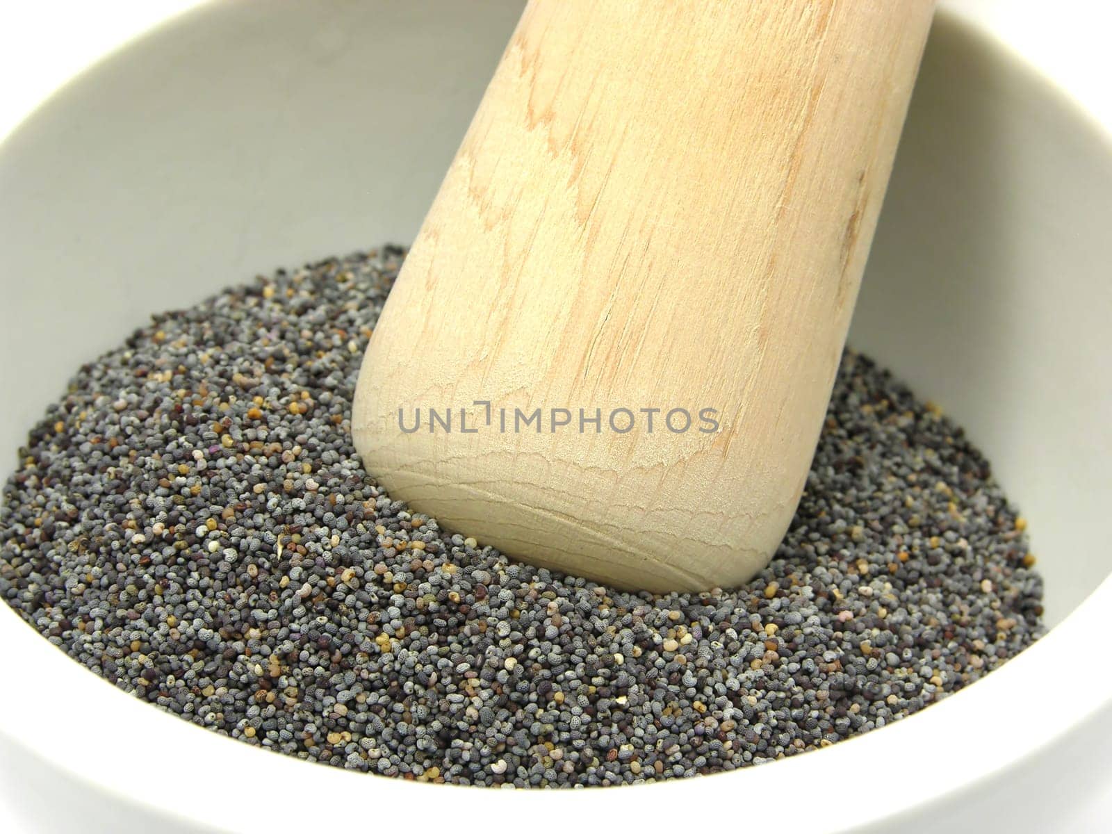 Poppy seeds in porcelain bowl with mortar