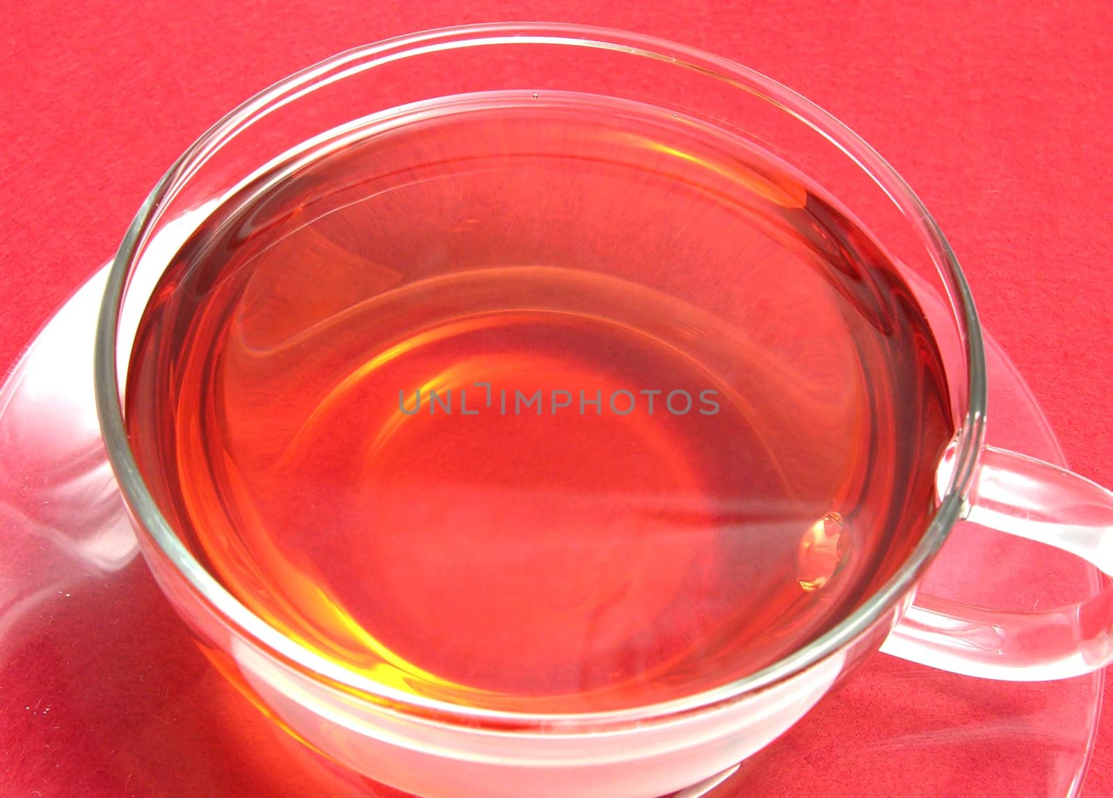 Teacup with rosehip tea on red placemat