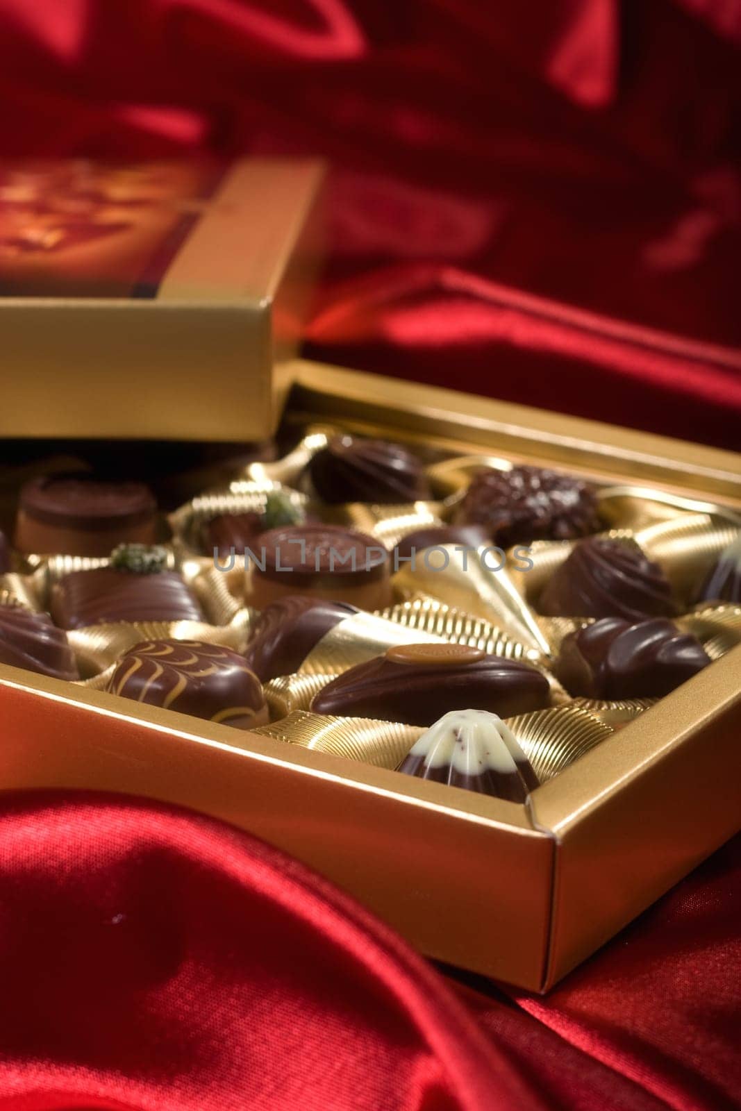 Golden chocolates box on red satin