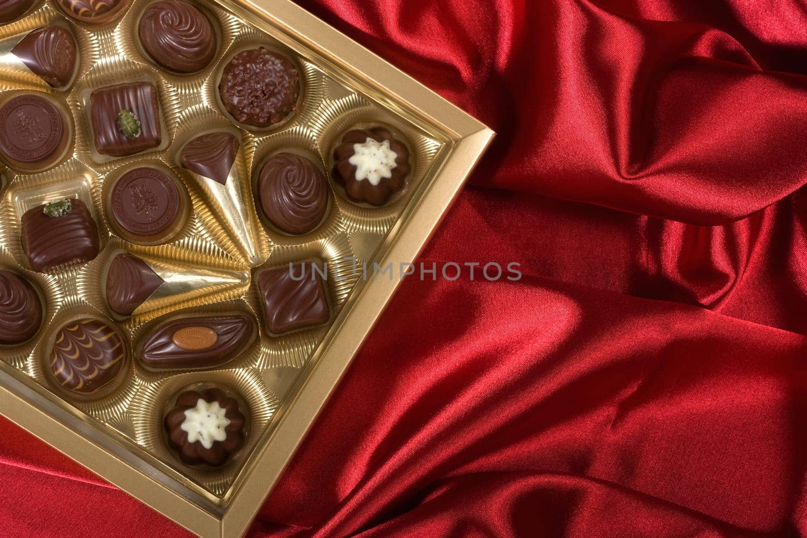 Golden chocolates box on red satin