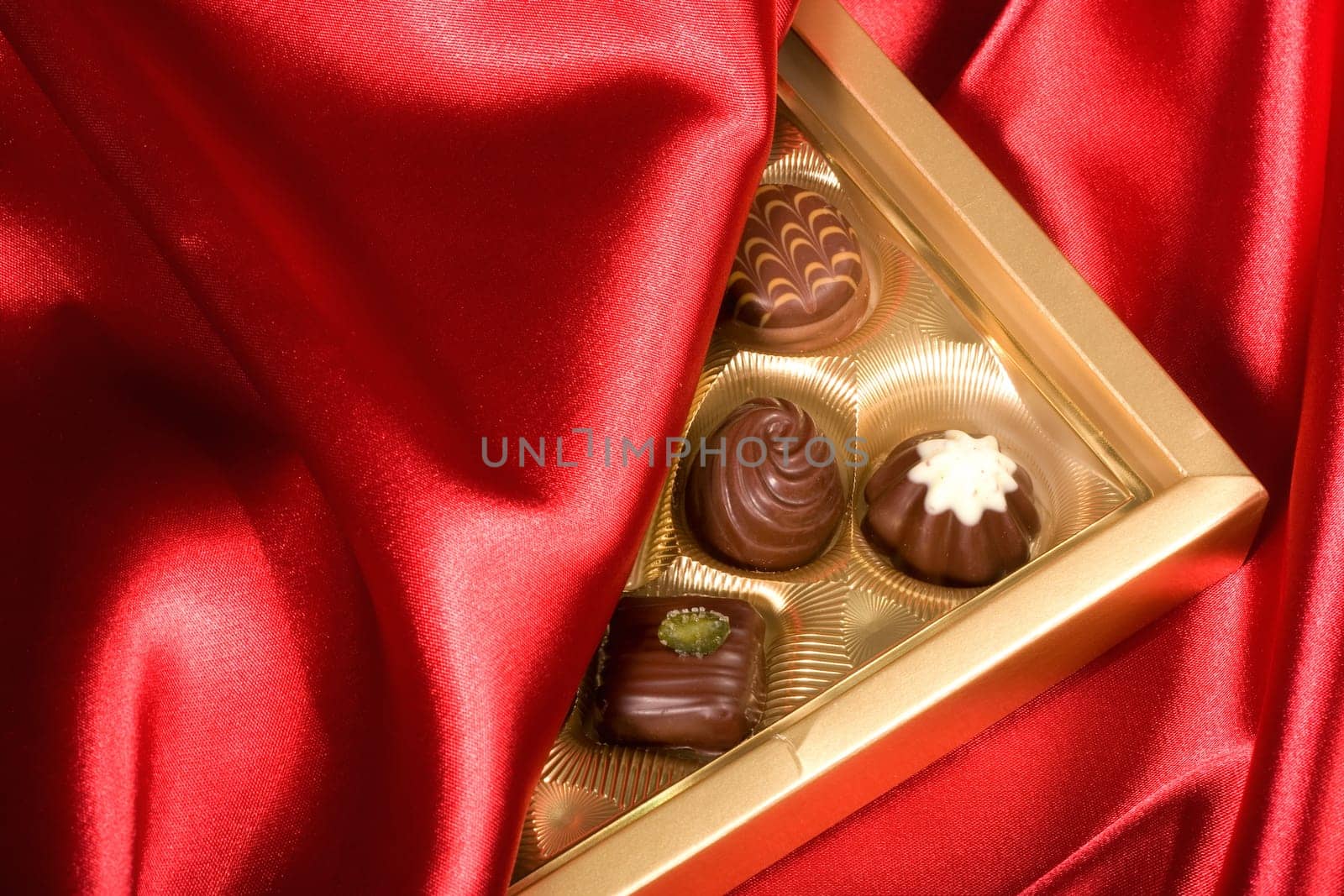 Golden chocolates box on red satin