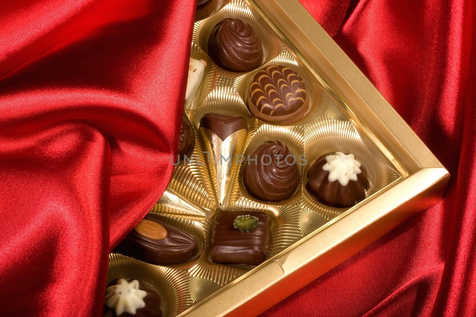 Golden chocolates box on red satin