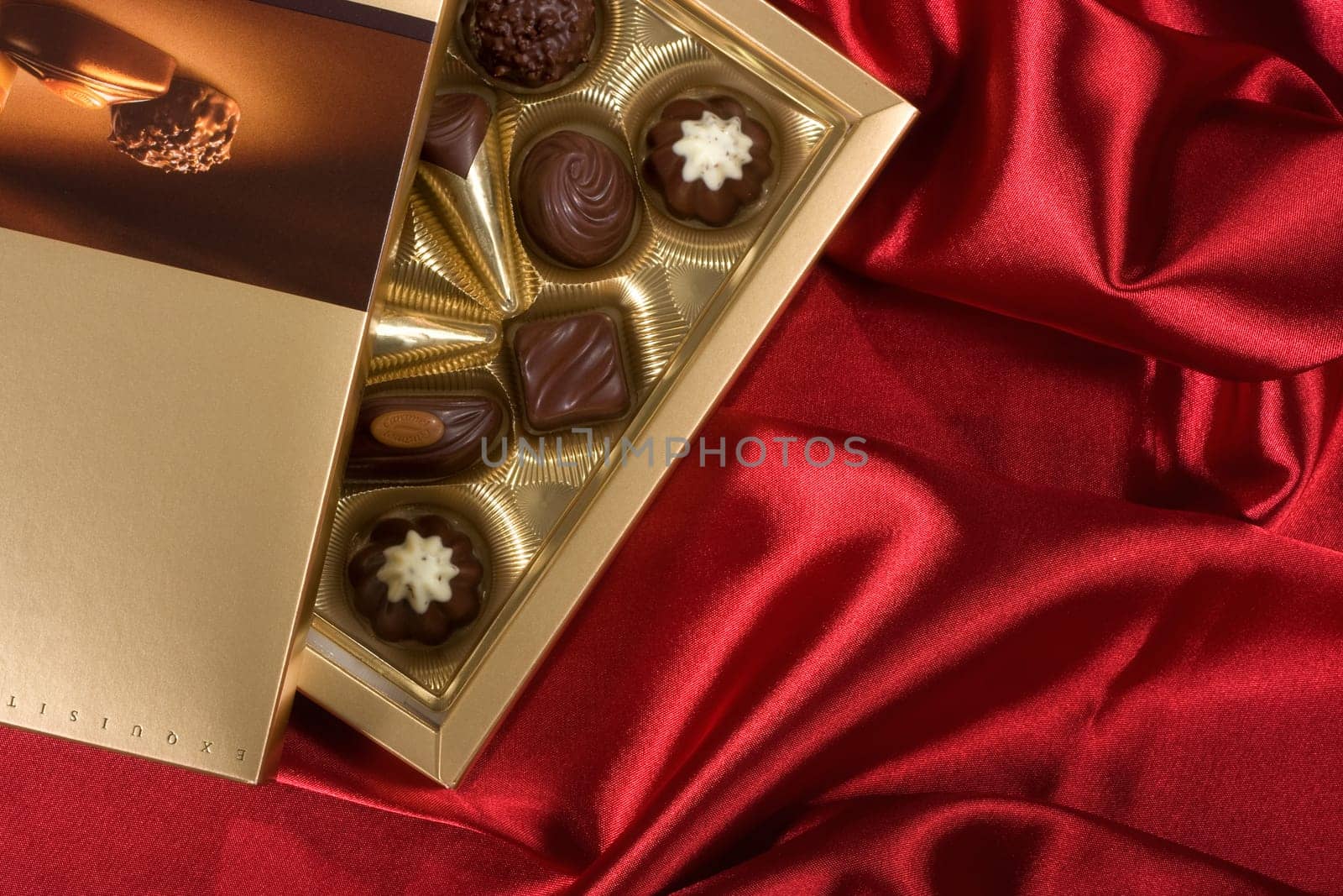 Golden chocolates box on red satin