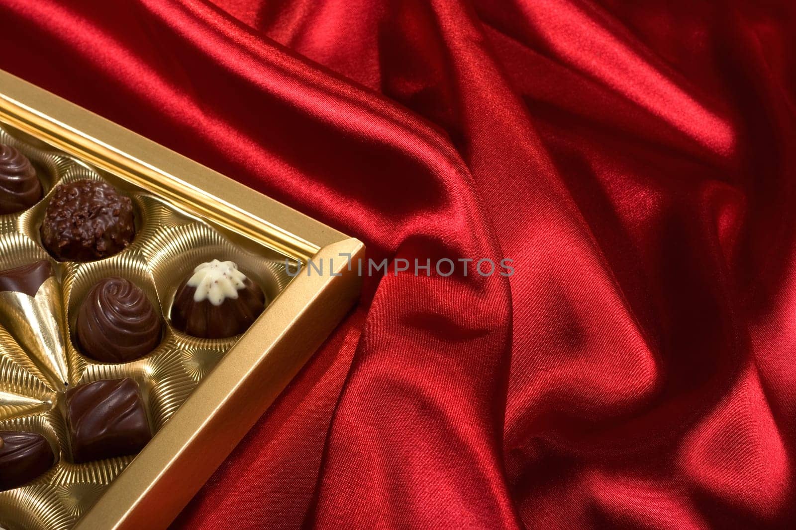 Golden chocolates box on red satin